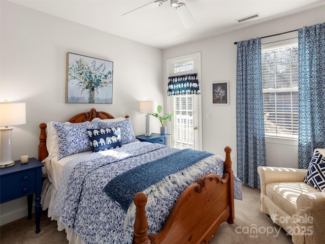 carpeted bedroom with multiple windows, visible vents, and a ceiling fan