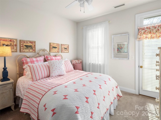 bedroom featuring baseboards, visible vents, a ceiling fan, and light colored carpet