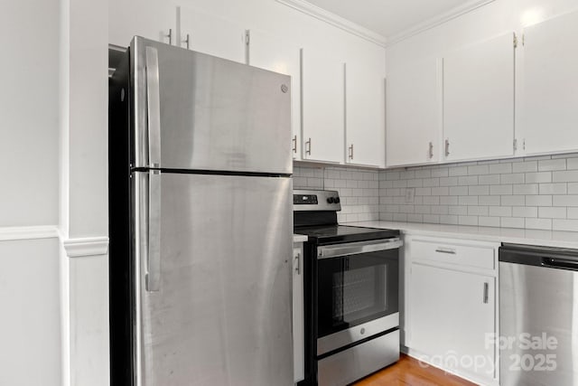 kitchen featuring white cabinetry, light countertops, ornamental molding, appliances with stainless steel finishes, and backsplash