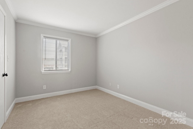 spare room with baseboards, crown molding, and light colored carpet