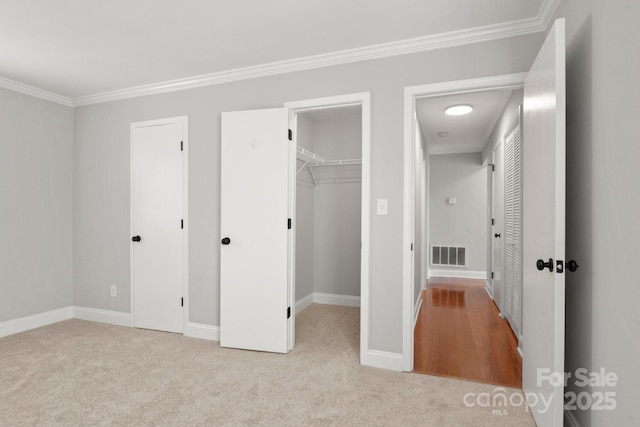 unfurnished bedroom featuring ornamental molding, visible vents, carpet floors, and baseboards