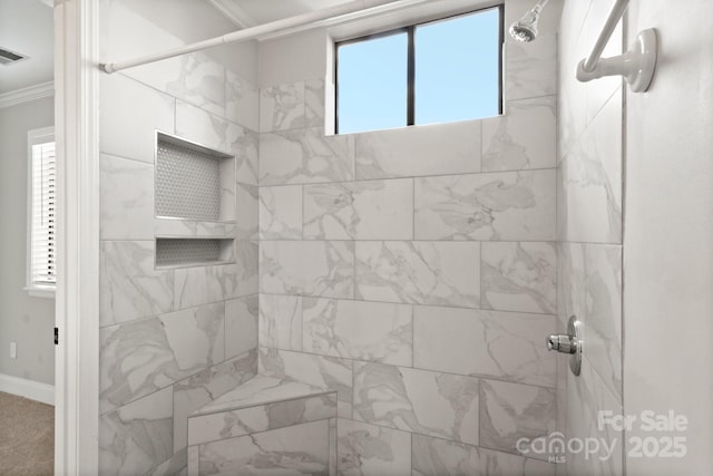 bathroom with ornamental molding and tiled shower