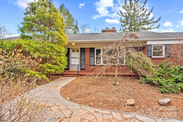 ranch-style home with brick siding and a chimney