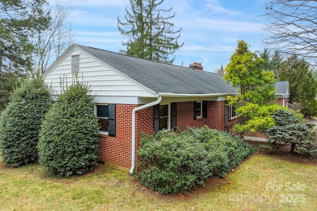 view of property exterior featuring brick siding, roof with shingles, and a chimney