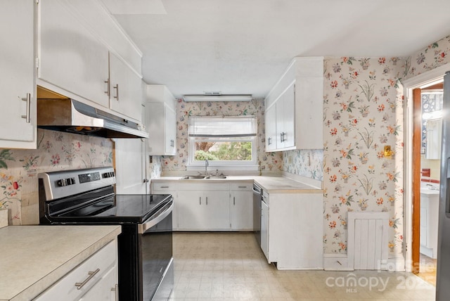 kitchen with wallpapered walls, under cabinet range hood, appliances with stainless steel finishes, and a sink