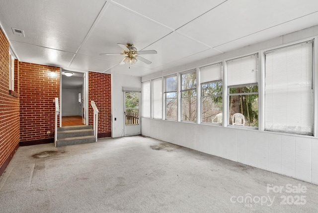 unfurnished sunroom featuring visible vents and ceiling fan