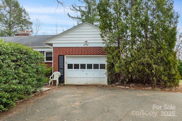 exterior space featuring brick siding, driveway, and a shingled roof