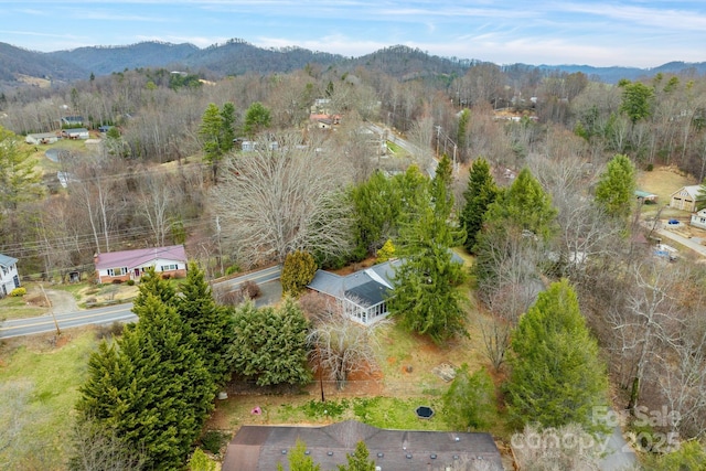 drone / aerial view with a wooded view and a mountain view