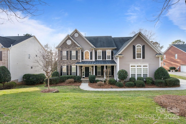 view of front of home featuring a porch, stone siding, and a front lawn