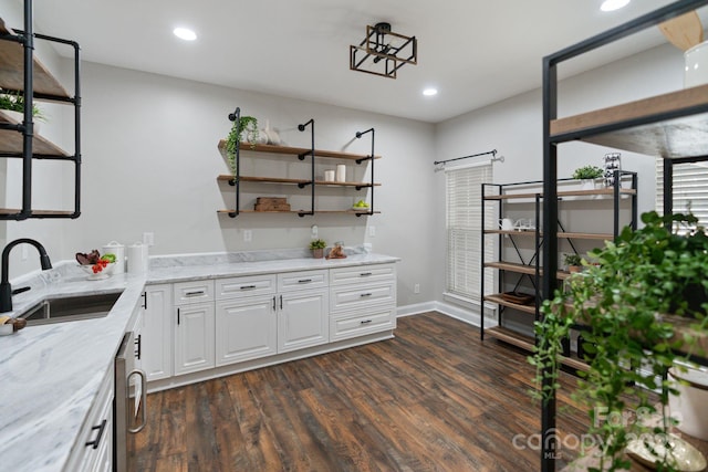 kitchen with white cabinets, dark wood finished floors, light stone counters, a sink, and recessed lighting