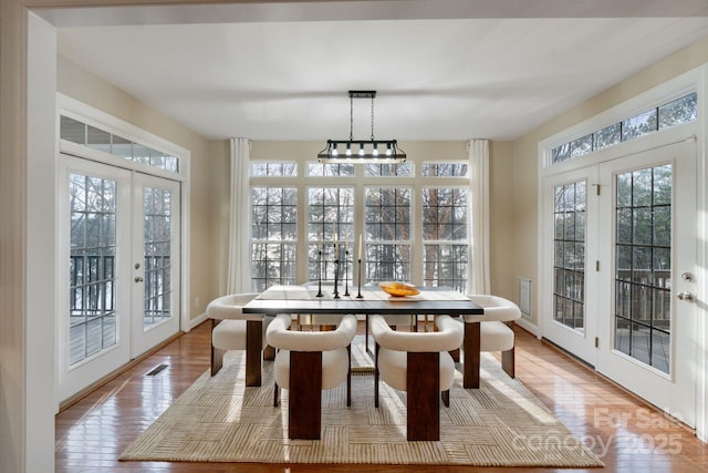 sunroom with visible vents, a wealth of natural light, and french doors