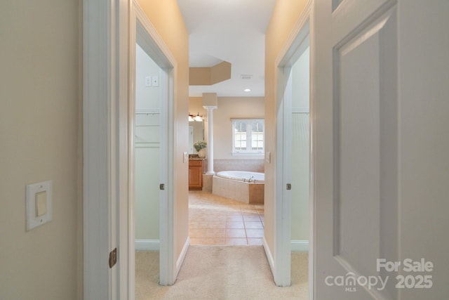 corridor featuring light carpet, light tile patterned floors, and recessed lighting