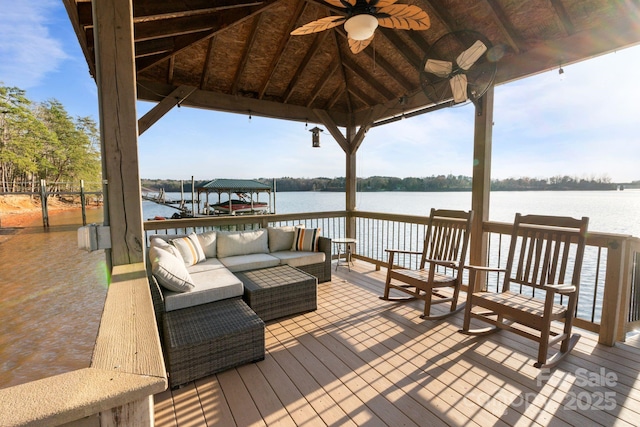 view of dock with a gazebo, a water view, and an outdoor living space