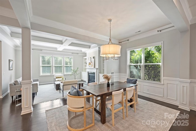 dining area featuring a wealth of natural light, beam ceiling, a fireplace, and ornate columns