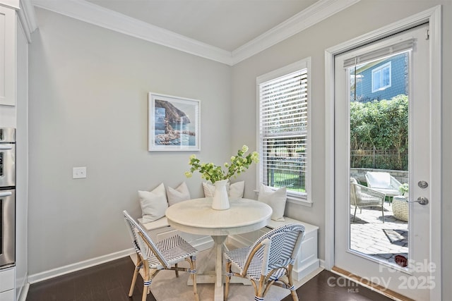 dining area featuring dark wood finished floors, crown molding, baseboards, and breakfast area