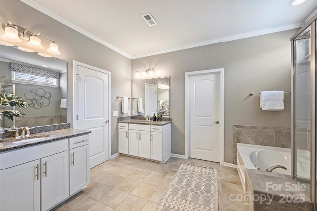 bathroom with visible vents, two vanities, a garden tub, and a sink