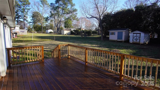 wooden deck featuring a storage shed, a yard, an outdoor structure, and fence