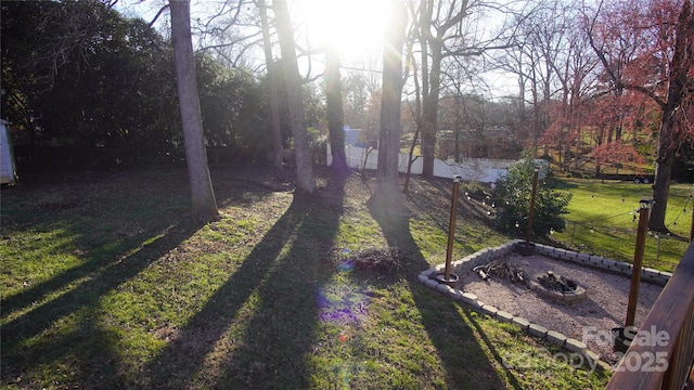 view of yard with fence and a fire pit