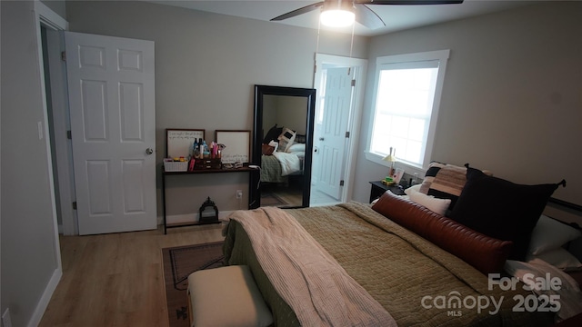 bedroom featuring a ceiling fan, baseboards, and wood finished floors