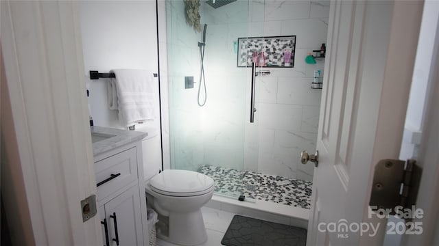 bathroom with marble finish floor, toilet, vanity, and a marble finish shower