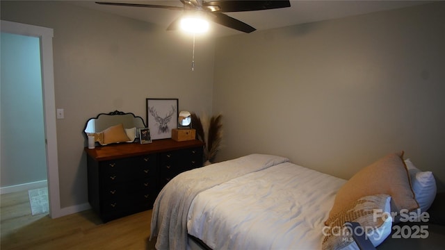 bedroom with light wood-style flooring, baseboards, and a ceiling fan