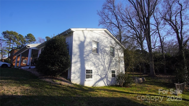 view of property exterior with a yard and brick siding