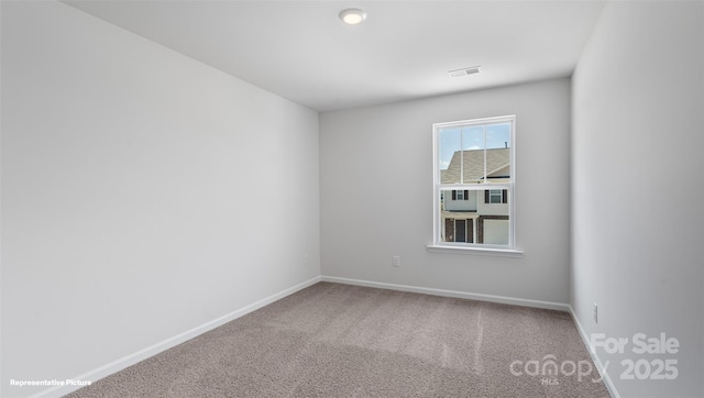 carpeted empty room with visible vents and baseboards