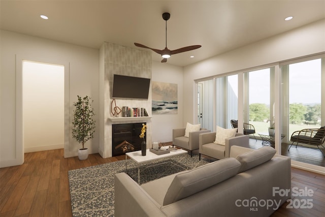 living area with recessed lighting, ceiling fan, wood finished floors, a tile fireplace, and baseboards