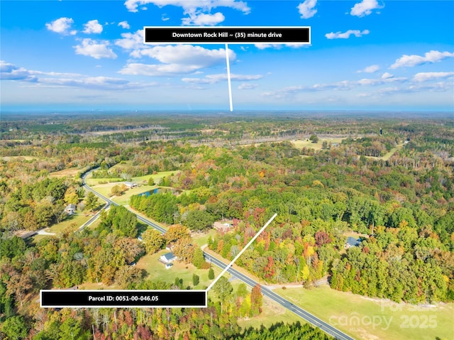 bird's eye view featuring a wooded view
