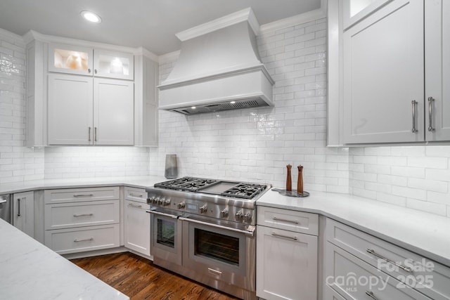 kitchen with dark wood-style floors, custom exhaust hood, glass insert cabinets, white cabinetry, and double oven range