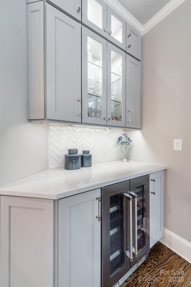 bar featuring tasteful backsplash, wine cooler, ornamental molding, and baseboards