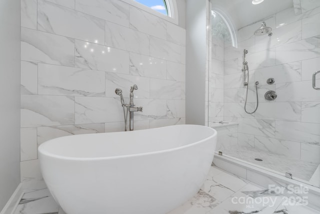 full bath featuring a freestanding bath, marble finish floor, and a stall shower