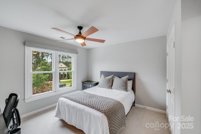 bedroom featuring ceiling fan, visible vents, baseboards, and light colored carpet