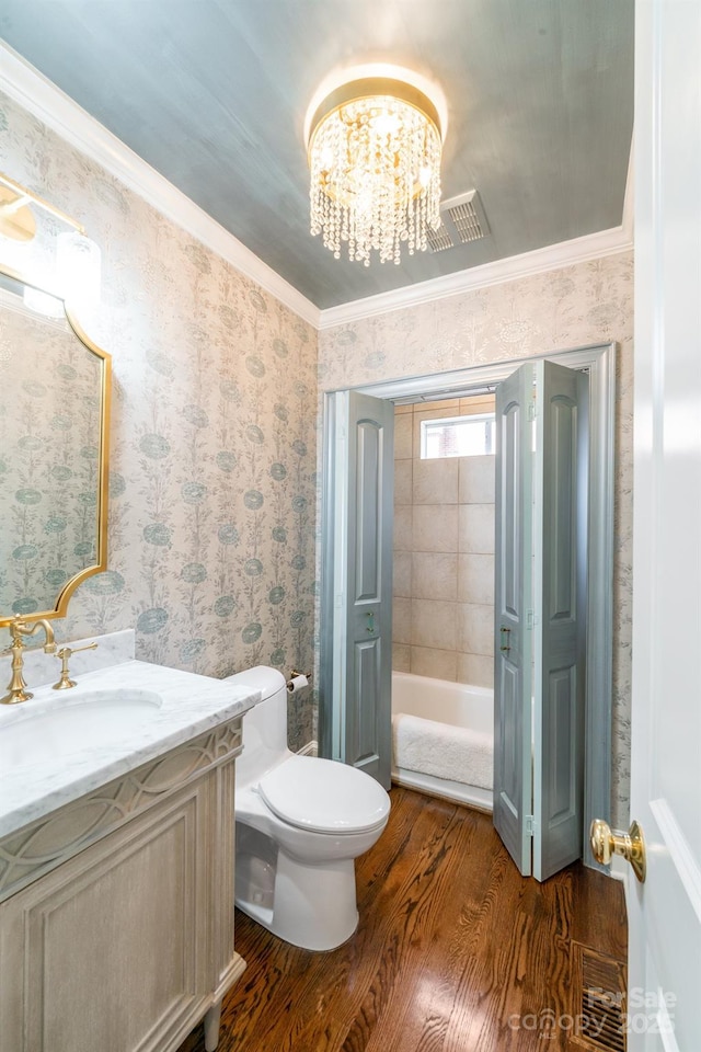 full bathroom with wallpapered walls, visible vents, ornamental molding, wood finished floors, and vanity