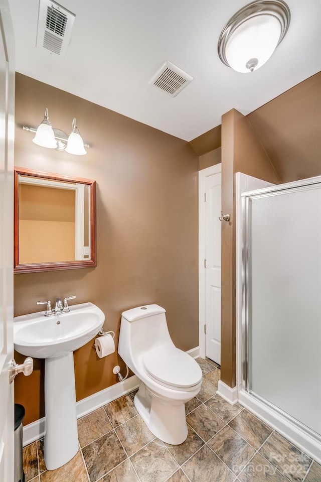 bathroom with toilet, a shower stall, visible vents, and baseboards