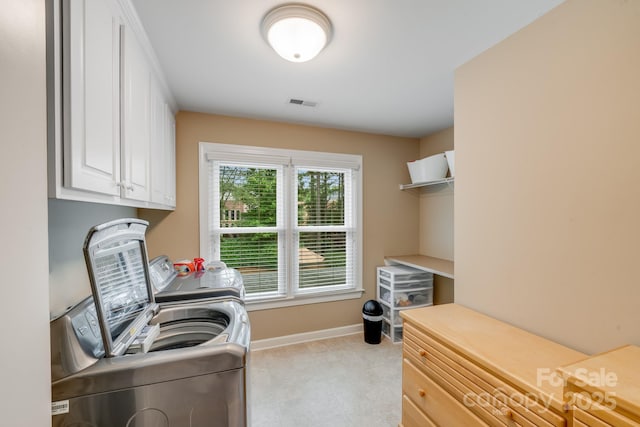 washroom featuring washer and dryer, cabinet space, visible vents, and baseboards