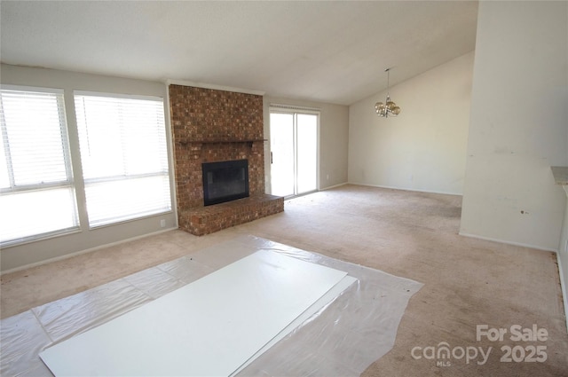 unfurnished living room with baseboards, lofted ceiling, carpet, a fireplace, and a chandelier