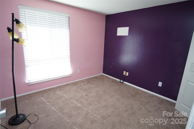 empty room with carpet and baseboards