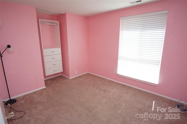 unfurnished bedroom featuring carpet flooring, visible vents, and baseboards