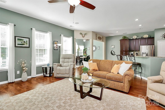 living area with recessed lighting, ceiling fan, baseboards, and wood finished floors