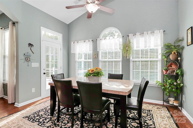 dining room with a wealth of natural light, lofted ceiling, and wood finished floors