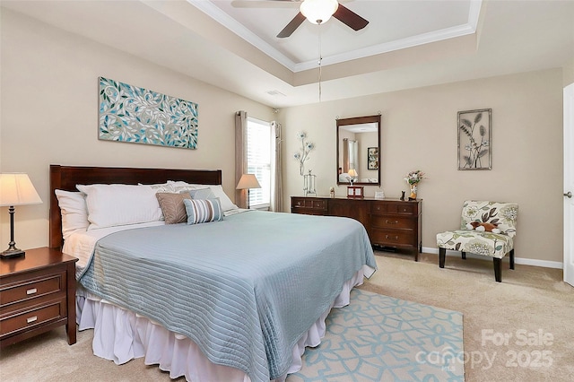 bedroom featuring ornamental molding, baseboards, a raised ceiling, and light colored carpet