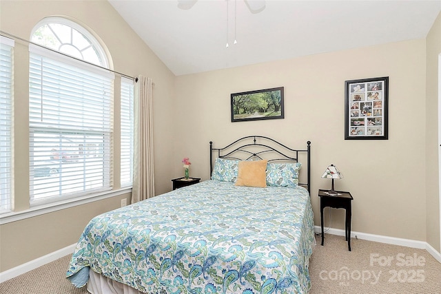 carpeted bedroom featuring lofted ceiling, multiple windows, and baseboards