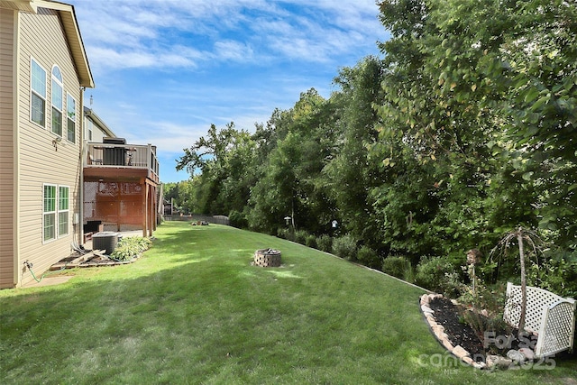 view of yard featuring an outdoor fire pit, cooling unit, and a wooden deck