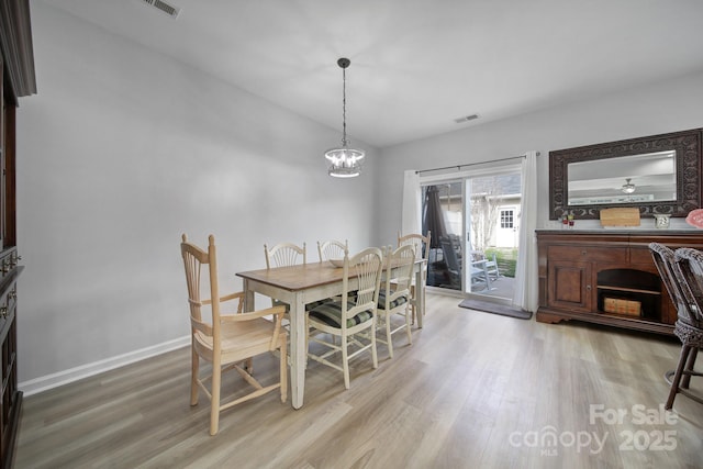 dining room with a notable chandelier, wood finished floors, visible vents, and baseboards