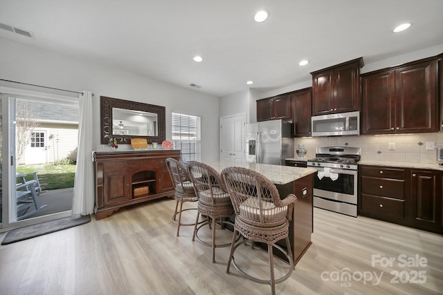 kitchen featuring a healthy amount of sunlight, visible vents, appliances with stainless steel finishes, and decorative backsplash