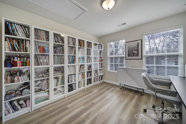 office area featuring baseboards, wood finished floors, visible vents, and attic access