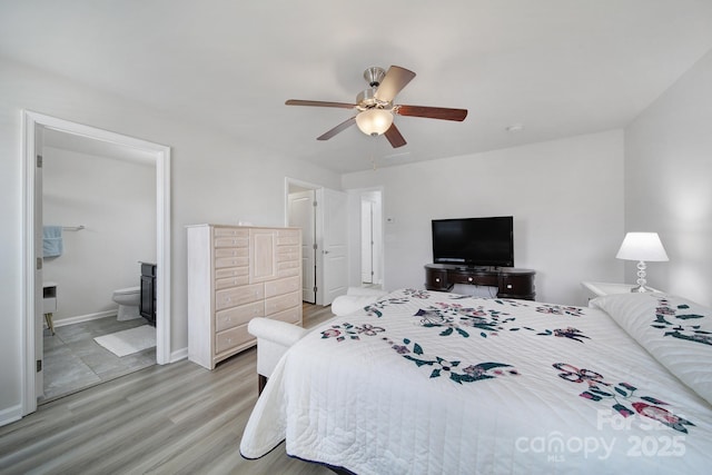 bedroom featuring light wood finished floors, a ceiling fan, baseboards, and connected bathroom