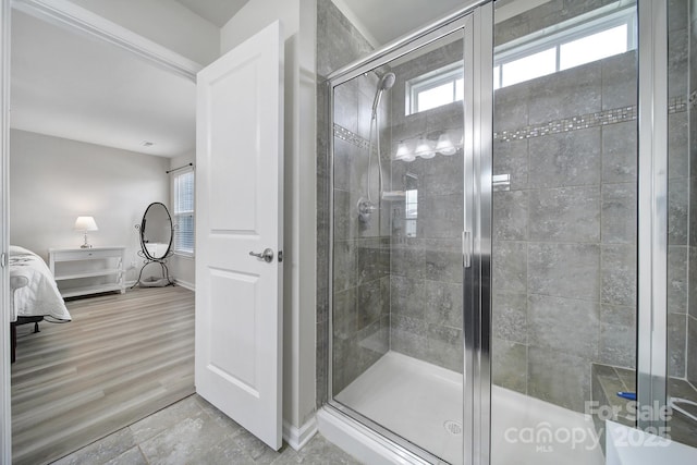 bathroom with a stall shower and baseboards