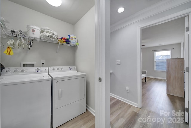 laundry room with light wood-style flooring, laundry area, washer and clothes dryer, and baseboards